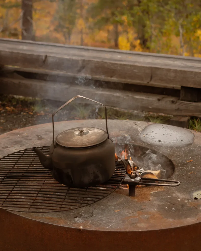 Ein Teekessel kocht auf einer Feuerstelle