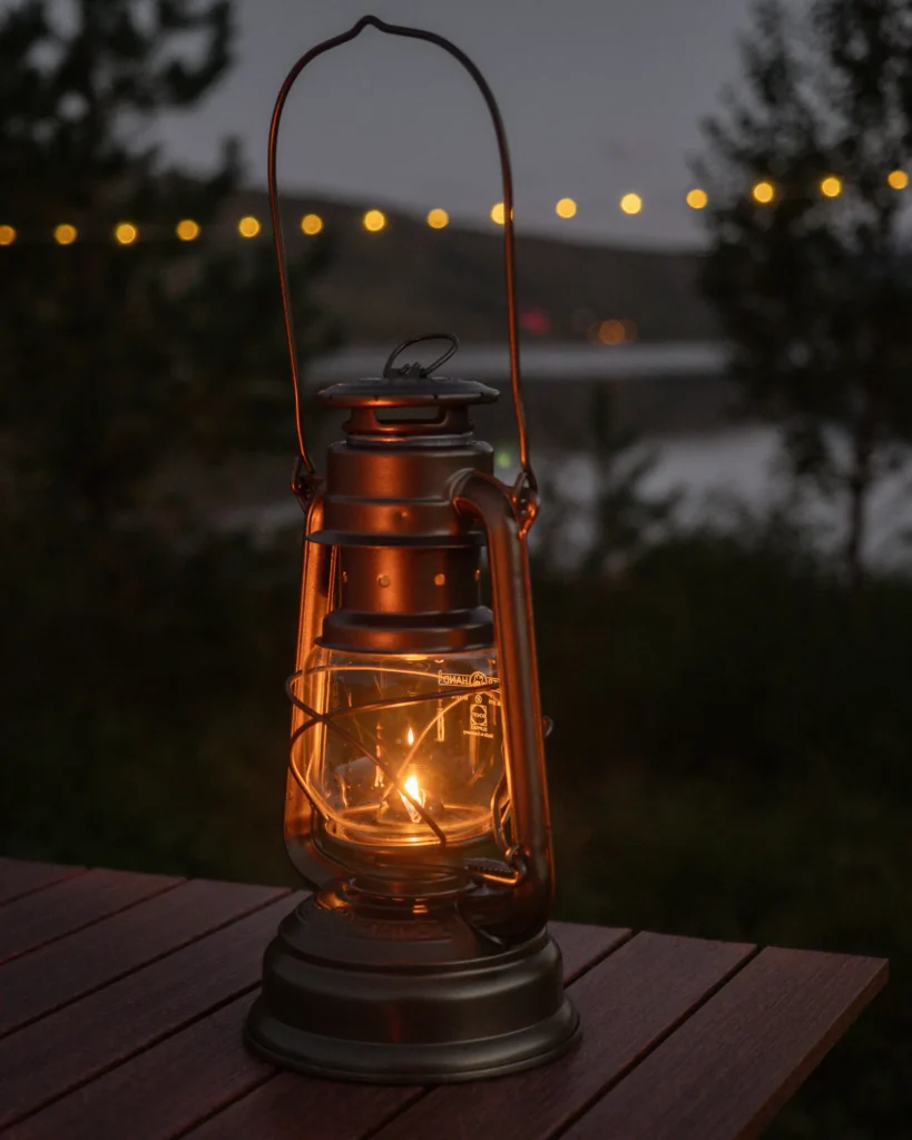 Eine Lampe steht auf einem Holztisch, Wasser und Lichterketten im Hintergrund