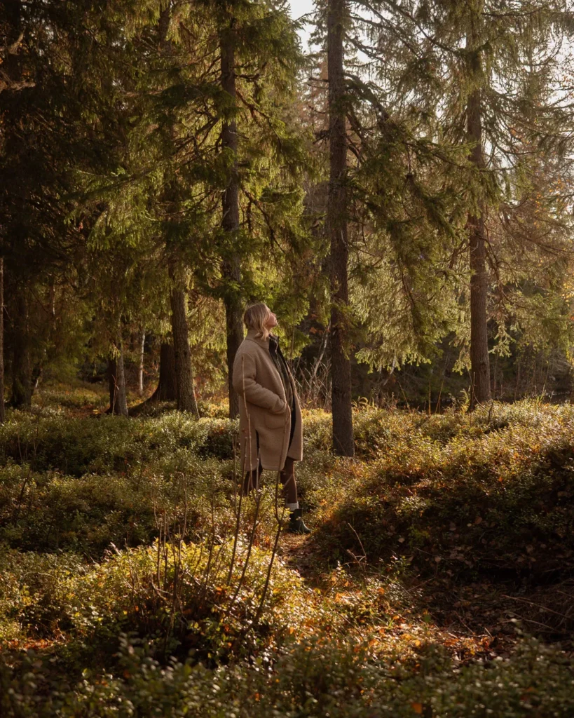 Vanessa von Be a Hyggespreder steht in einem Wald in Norwegen